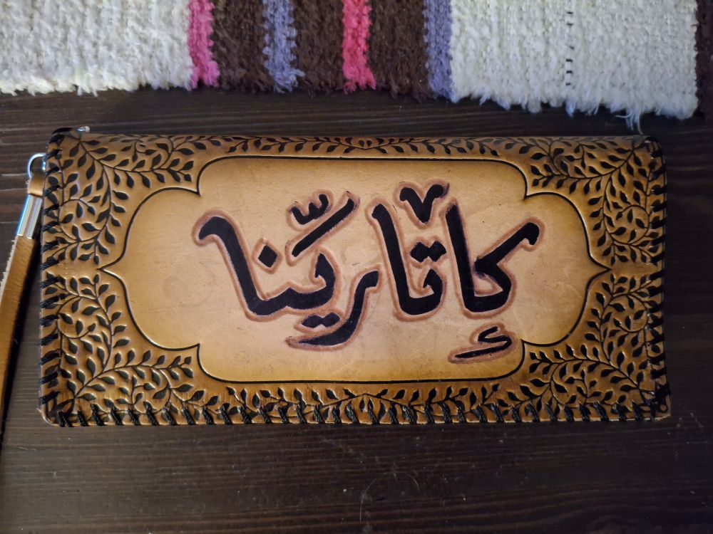 Lompakko, jossa lukee arabiaksi Katariina.