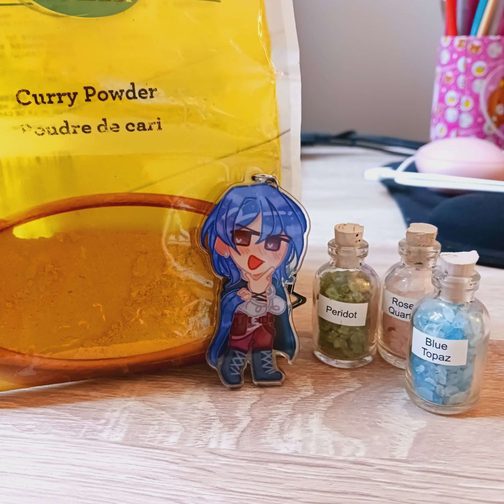 Bee's Balor charm posed with some curry powder and gemstone shards.