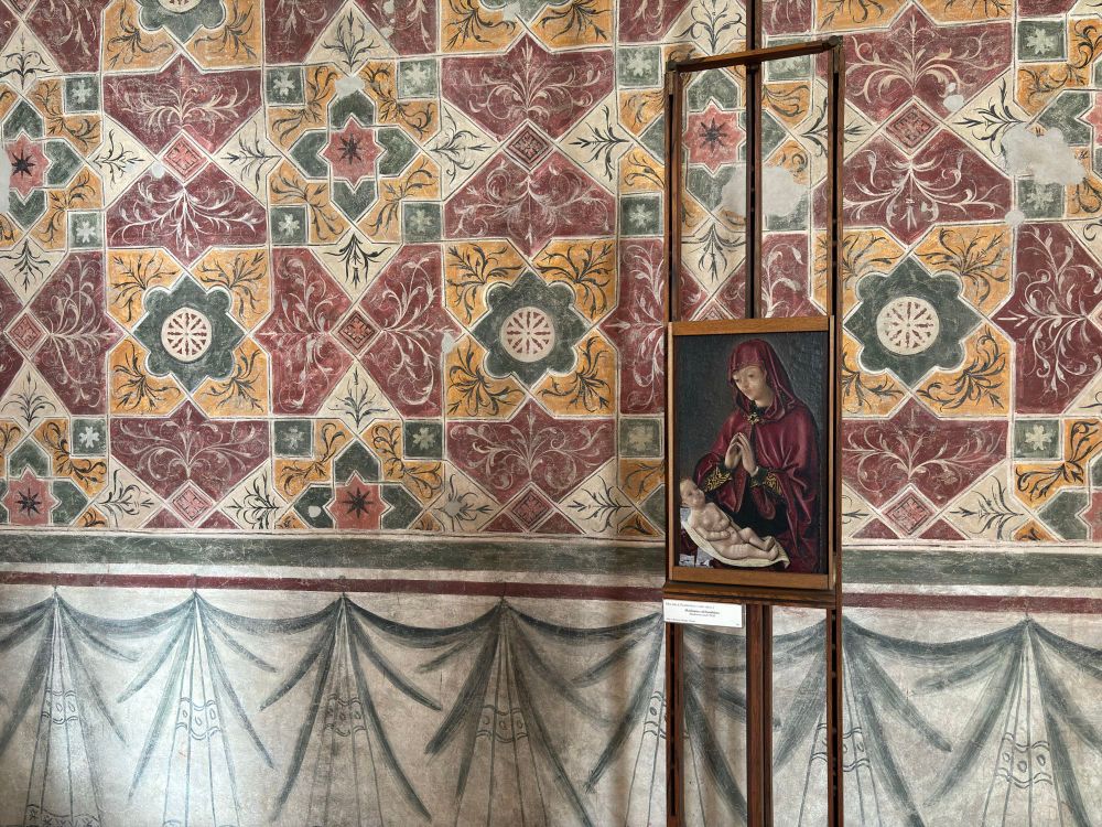 The Virgin, Mary, with the infant Jesus. Small early Renaissance painting on an easel before a decorated wall in Castelvecchio, Verona. Happy Christmas to those who celebrate.