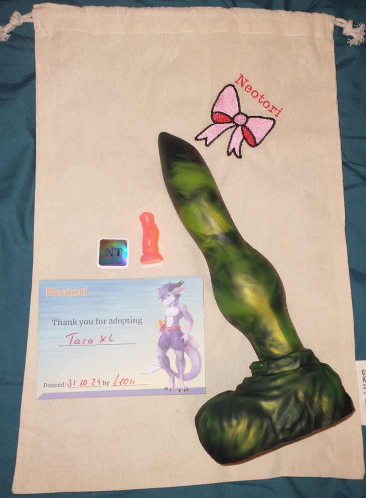 Picture of an XL Taco from Neotori, along with a sticker, a thank you card, and mini model of a different toy.