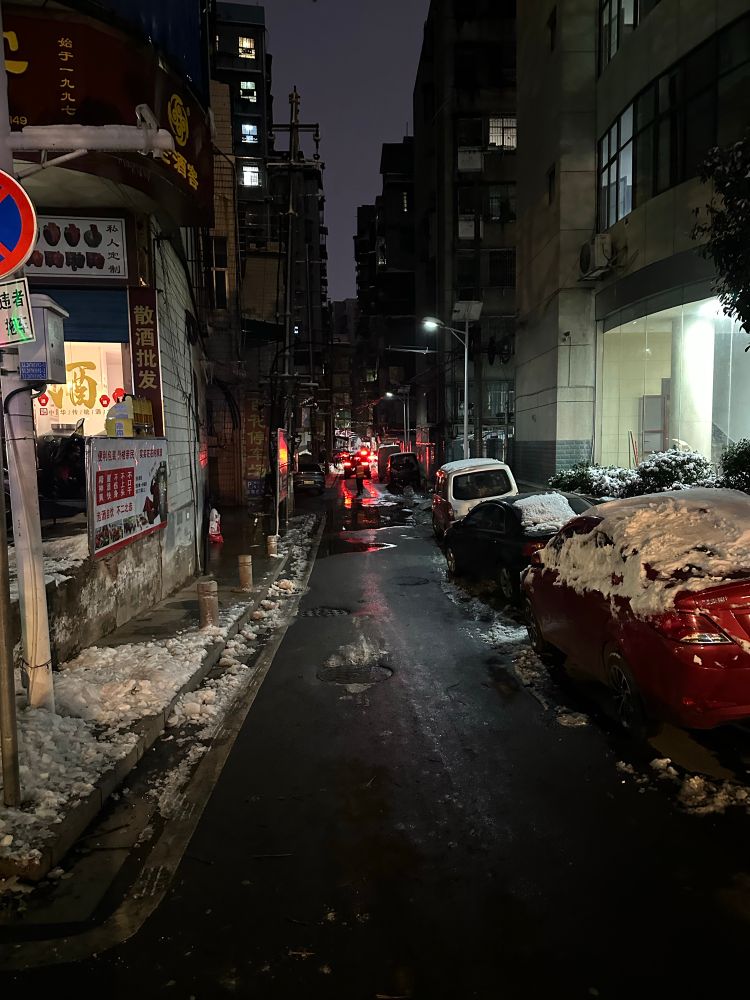 A alleyway with snow-covered cars