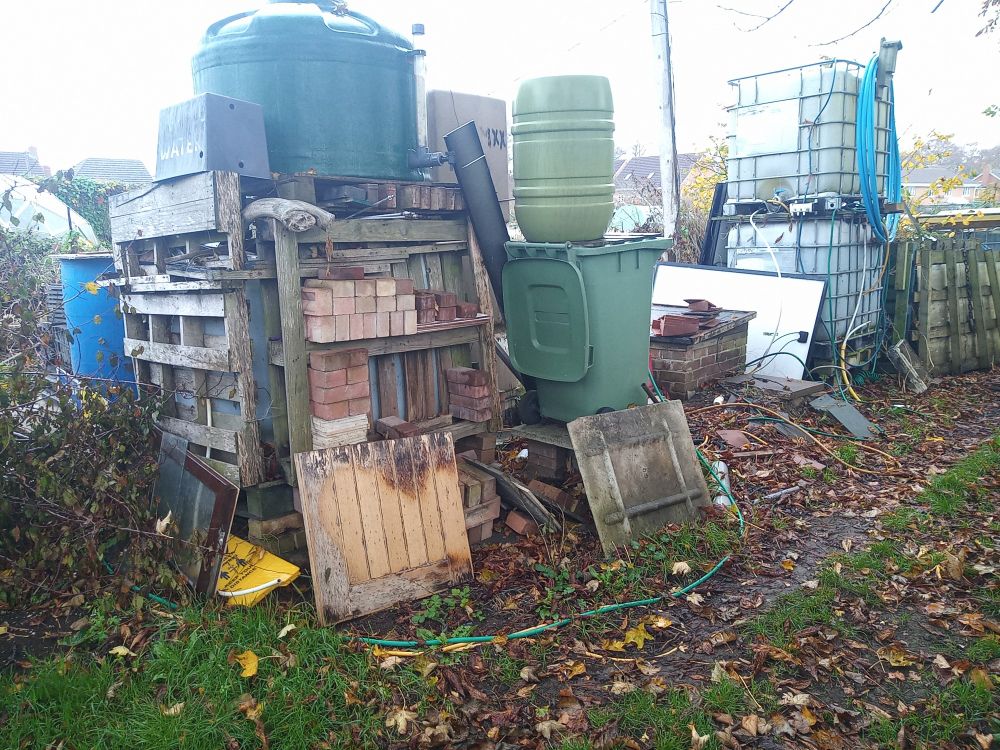 Another view of the various storage tanks and the framework made of pallets that surrounds them.