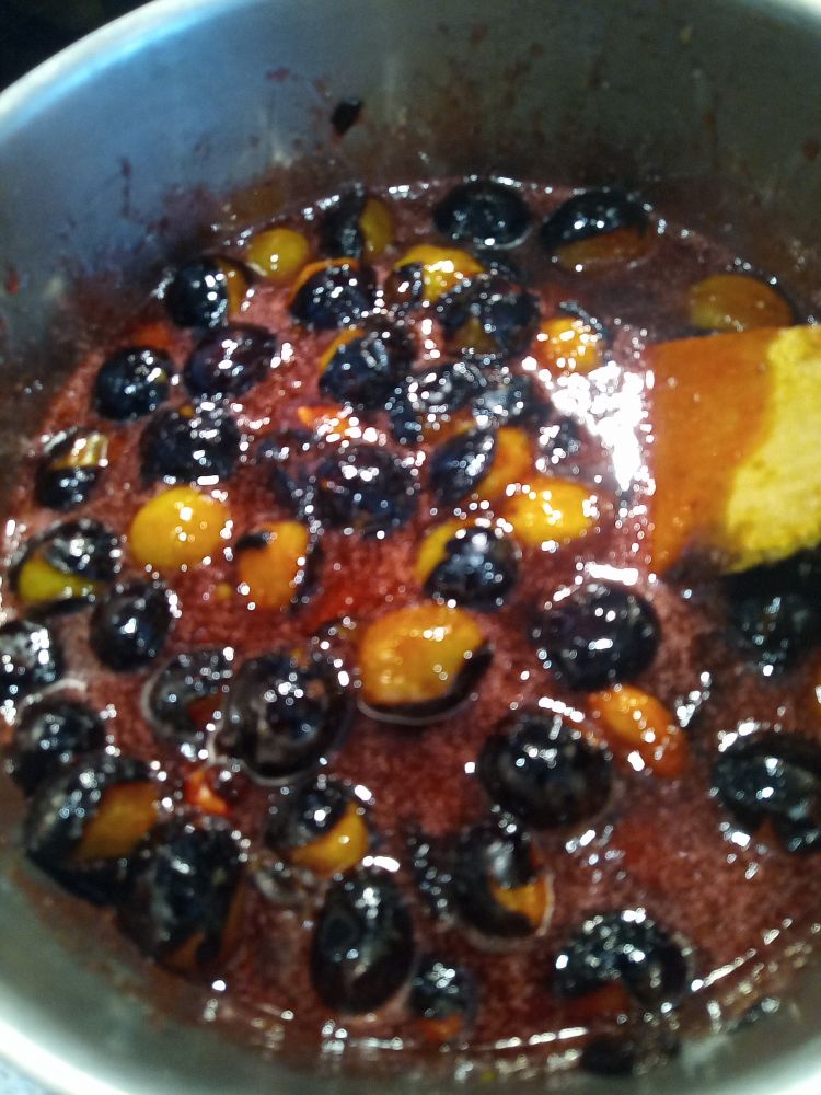 Damsons just starting to break up in the jam pan.