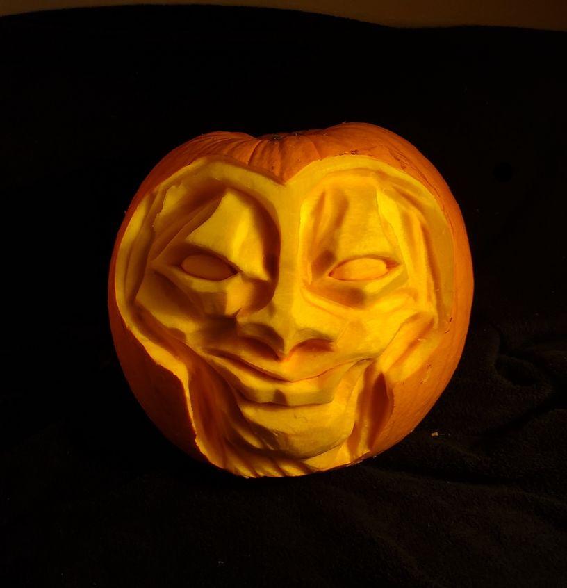 A pumkin sculpture that looks like a dude wearing some kind of helmet. The expression looks a little smug