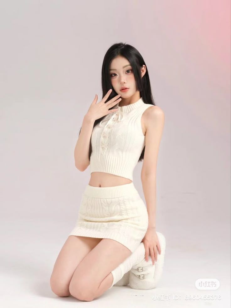 picture of a model kneeling, wearing a white two piece set