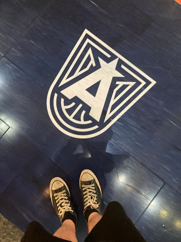 my feet standing by the Atlanta Dream logo