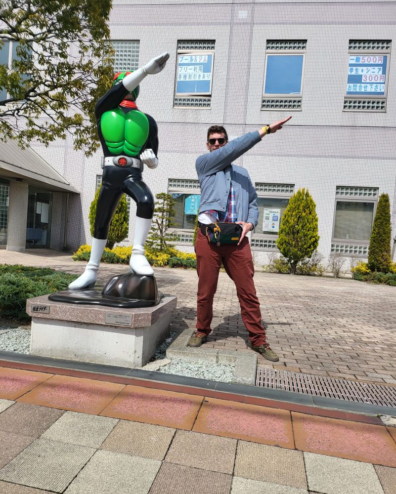 The author posing alongside a Kamen Rider statue.