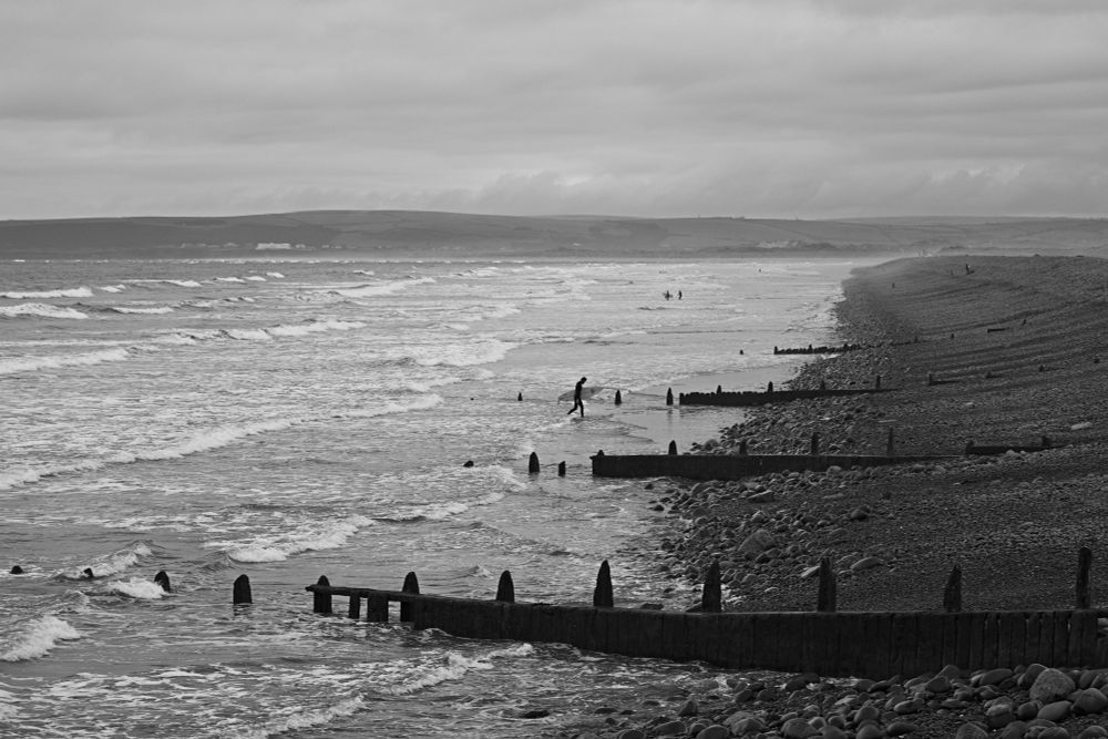A surfer returns from a day out in the waves