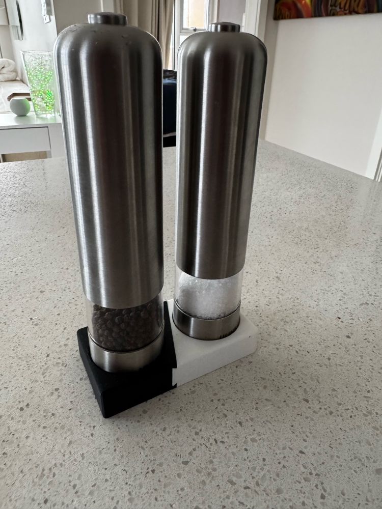 Stainless and plastic salt and pepper on a kitchen counter.