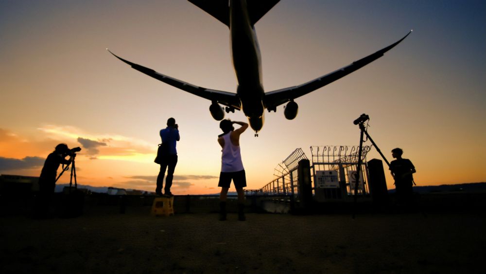 夕暮れ時に伊丹空港に着陸するBoeing787とそれを撮る人々