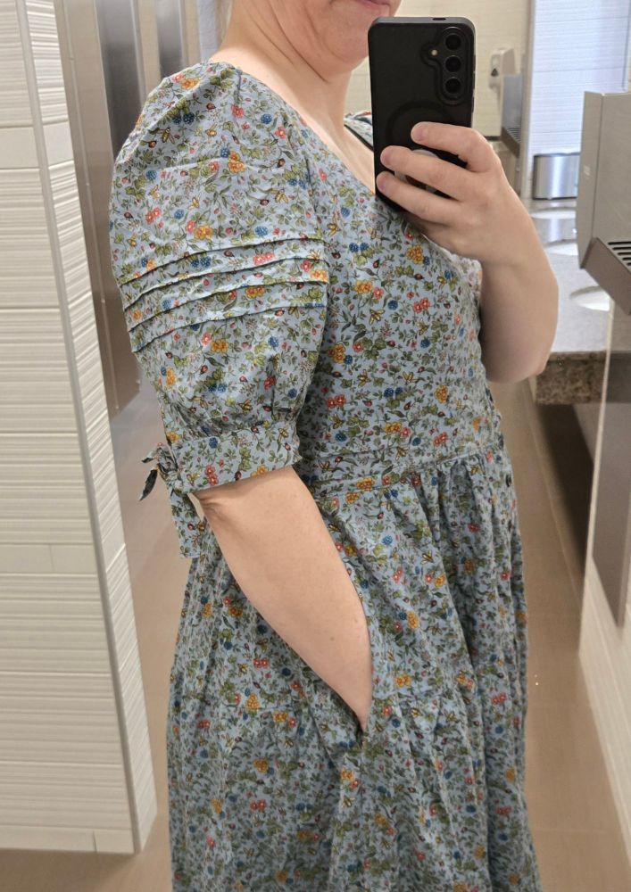 Side profile of the blue dress to show the pin tucks on the sleeve.