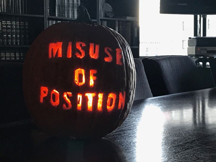 Pumpkin with "Misuse of of Position" carved into it
