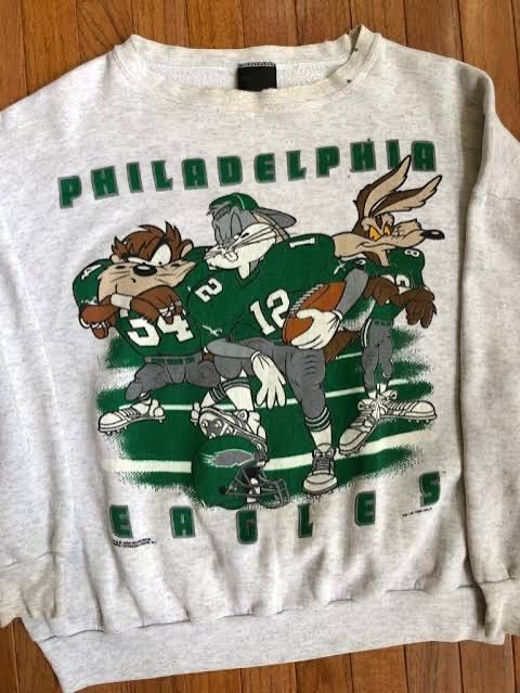 Old 90s Eagles-themed grey pullover with Bugs Bunny, the Tasmanian Devil, and Wile E. Coyote from Looney Tunes in Eagles gear. They are mean mugging and looking tough, as was the style at the time