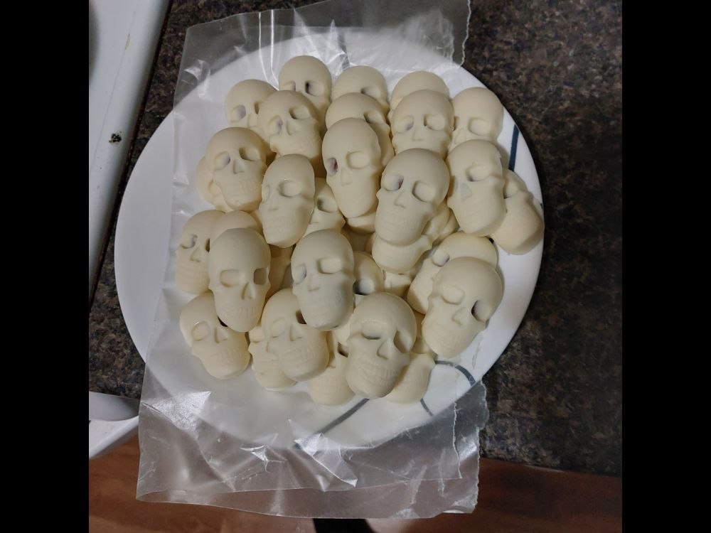 A plate holding a pile of skulls made from white chocolate.