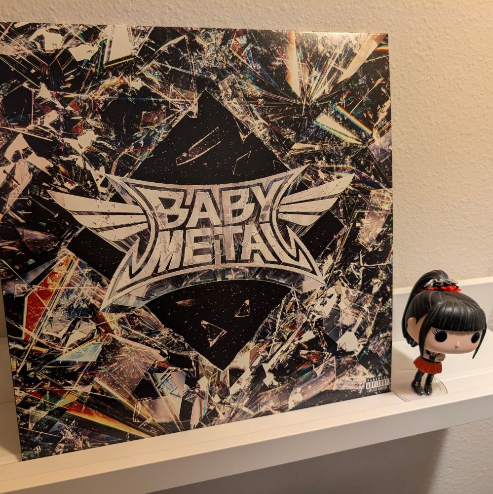 The cover for Babymetal's 'Metal Forth' album, propped up on a white shelf, next to a Funko POP figure of Su-Metal