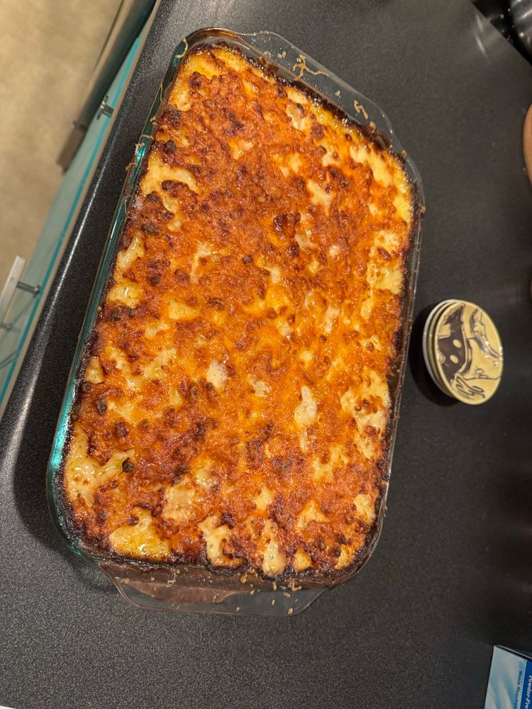 A sheet of baked mac and cheese resting on the counter. Behind it is a Vivi plate from the recent FF9 kuji.