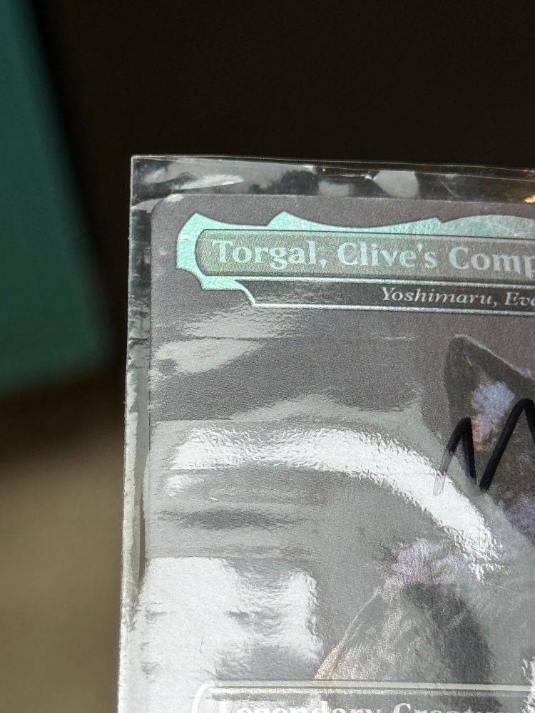 A view of Torgal, Clive’s Companion promo MTG card that shows damage on the penny sleeve it came in.