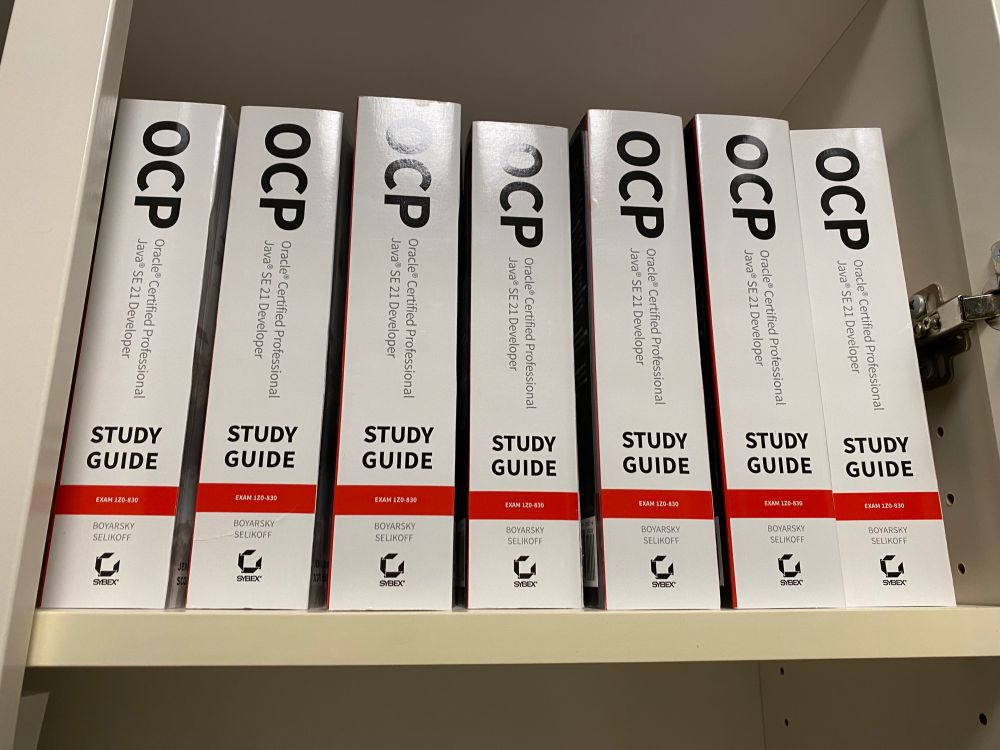 7 copies of OCP Java SE 21 Developer Study Guide lined up on a shelf