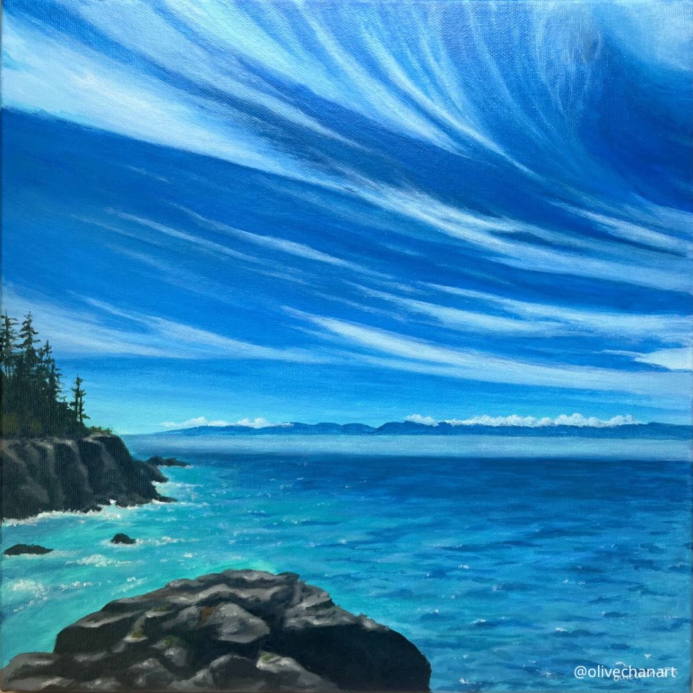 A square painting of a vibrant blue sky with sweeping wispy clouds over a turquoise ocean. To the left is a bit of rocky land with evergreen trees. In the foreground is a large boulder. The water sparkles in the su sunshine. 