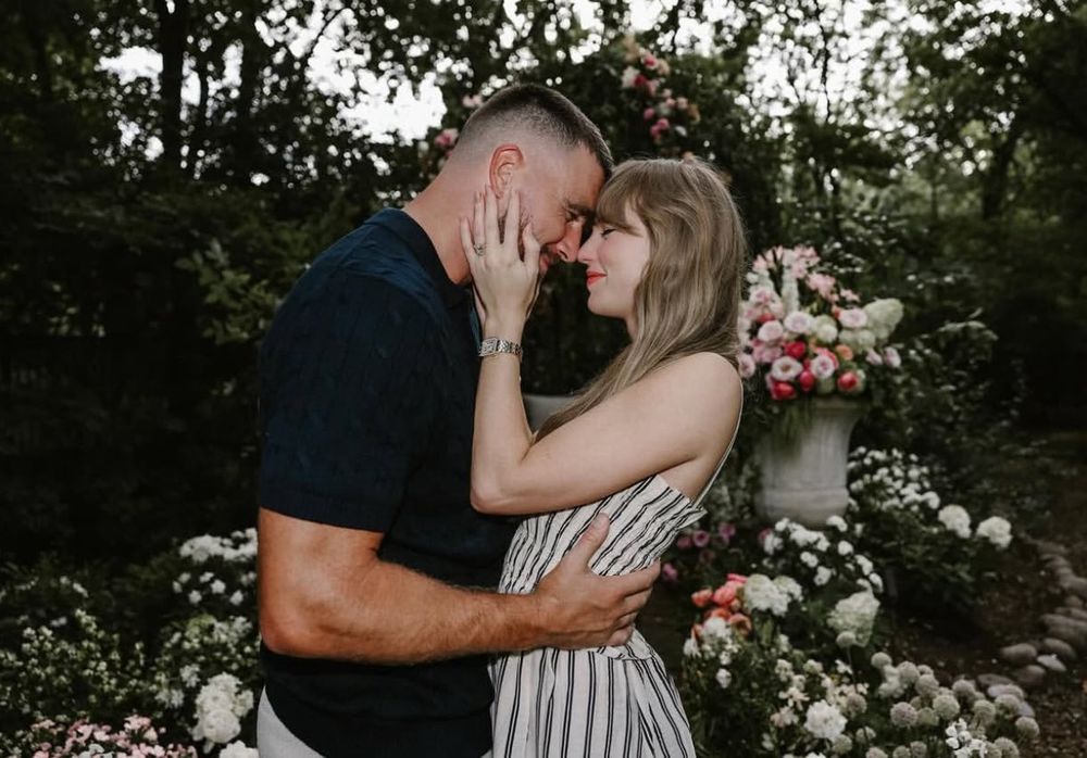 a taylor swift and travis kelce engagement photo with taylor’s hands on his face and his arms on her waist 