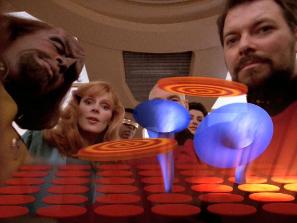 An image of the addictive game from Star Trek: The Next Generation "The Game" episode with Riker, Picard, Crusher, Troi, Worf, and La Forge in the background while those sooooooothing discs float into those lovely purple bells. Ahhhhhhhhh.