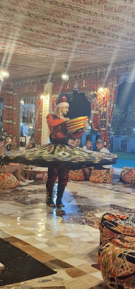 Tanzdarbietung im Derwisch Style.
Junger Mann mit Trommel in einem bunten Kostüm mit weitschwingendem Rock