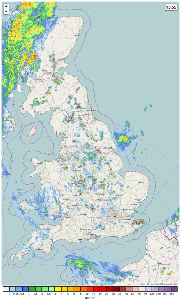 Map of the United Kingdom with weather radar data overlaid showing isolated cells of heavy precipitation running along the long length of Great Britain.