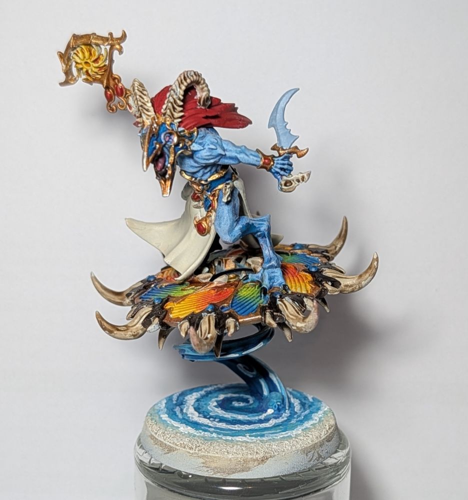 a colourful tzaangor shaman with a rainbow disc and a beach themed base
