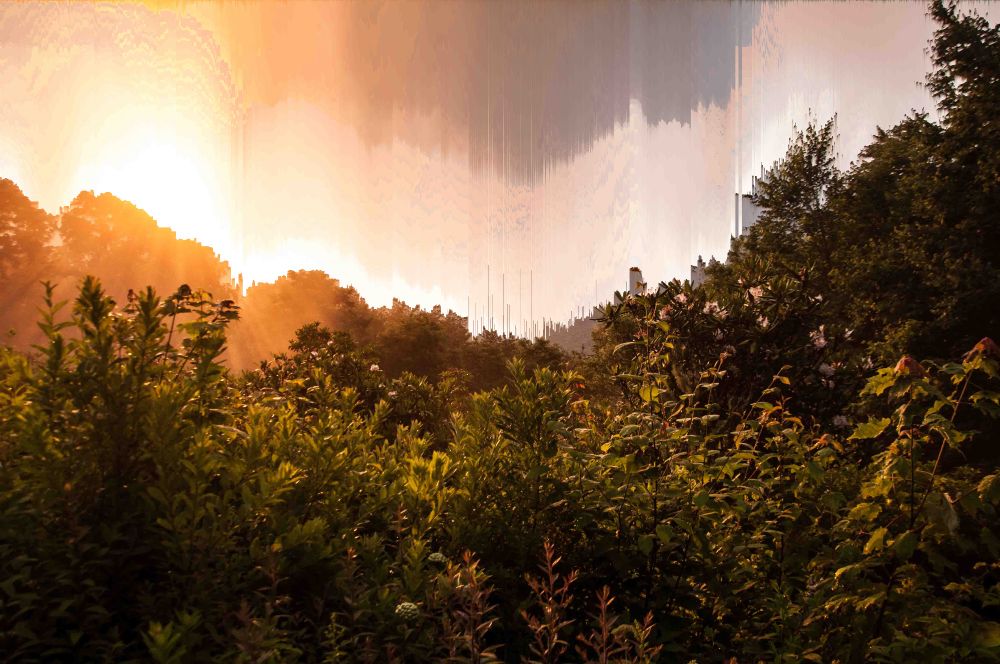 A photograph of the blue ridge mountains with the clouds in the background artificially streaking upwards.
