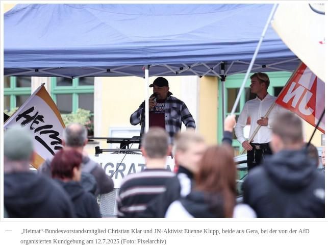 Foto von Christian Klar und Etienne Klupp am 12.7.25 in Apolda. Beide stehen unter einem Pavilon. Klar hält ein Mikrofon in der Hand, in das er spricht. Klupp steht daneben und trägt eine Fahne der JN. Bildunterschrift: „„Heimat“-Bundesvorstandsmitglied Christian Klar und JN-Aktivist Etienne Klupp, beide aus Gera, bei der von der AfD organisierten Kundgebung am 12.7.2025 (Foto: Pixelarchiv)“