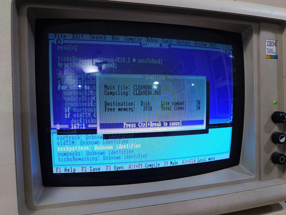 An IBM 5153 CGA color monitor showing Pascal source code being compiled.
