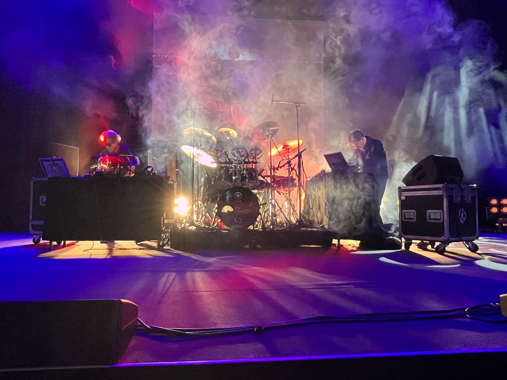 2 Frickler, 1 Schlagzeug in der Mitte, Nebel, Licht