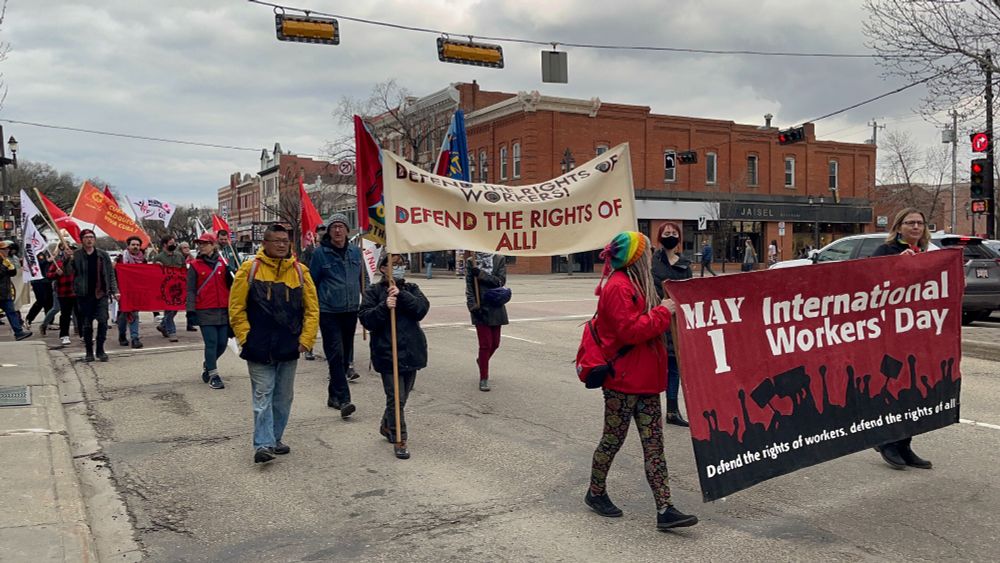 May Day marchers holding signs marching down Whyte Avenue.