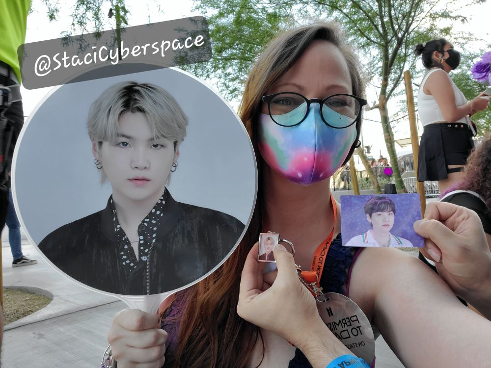 Me waiting outside for PTD Vegas in 2022. There's multiple Yoongi images being held up by my face. 