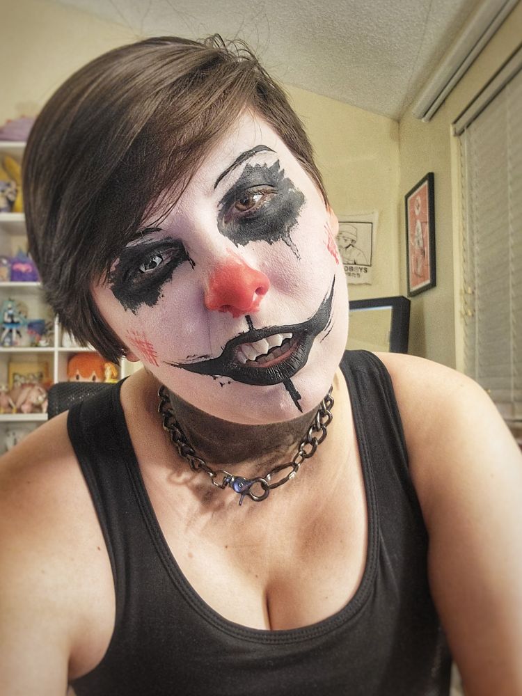 Painted up like a scary clown in black white n red paint, snarling w sharp teeth n chain collar