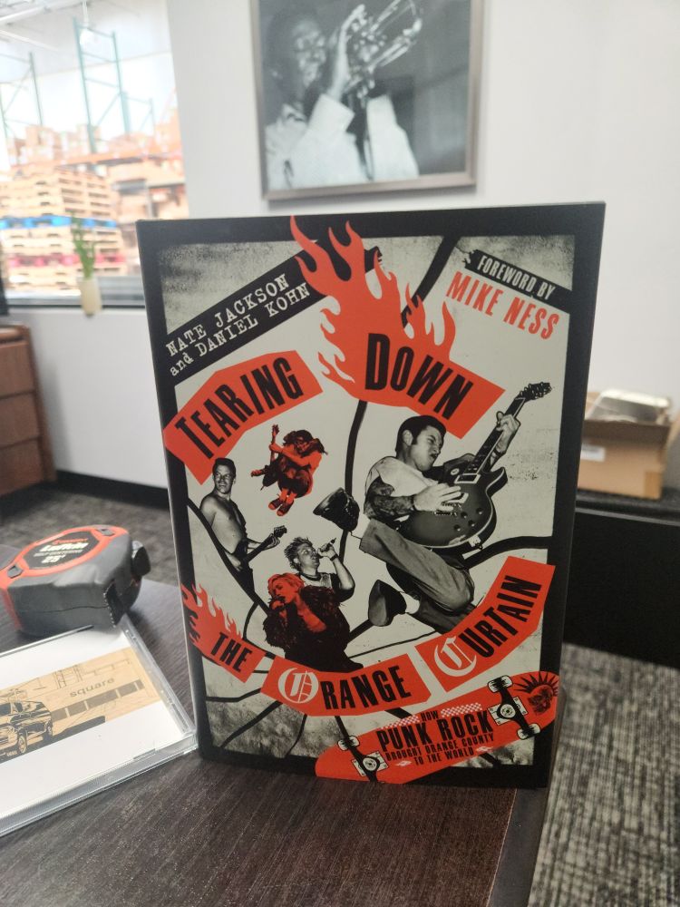 The image is of the book titled "Tearing Down The Orange Curtain -  How Punk Rock Brought Orange County to the World"