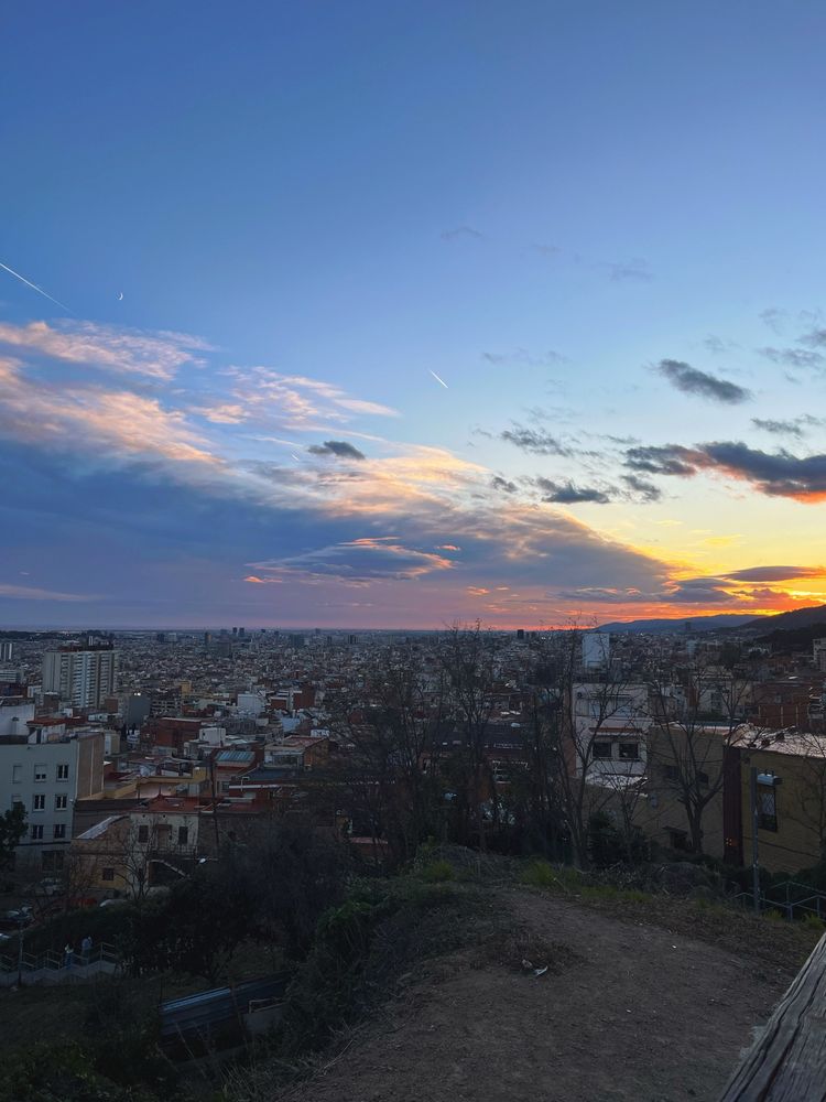 The view from above Barcelona, sun setting behind clouds