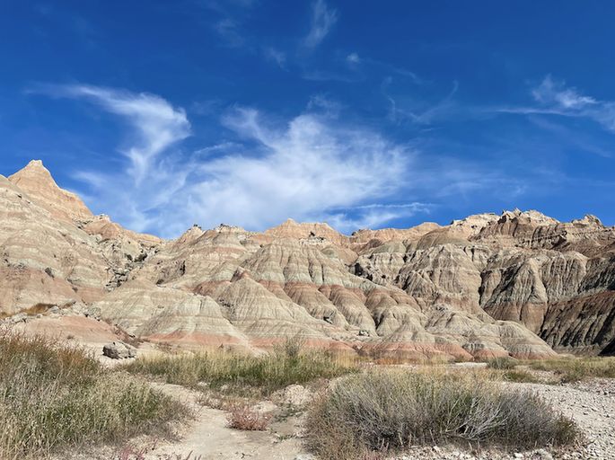 Red and white striped rocks under a deep blue sky