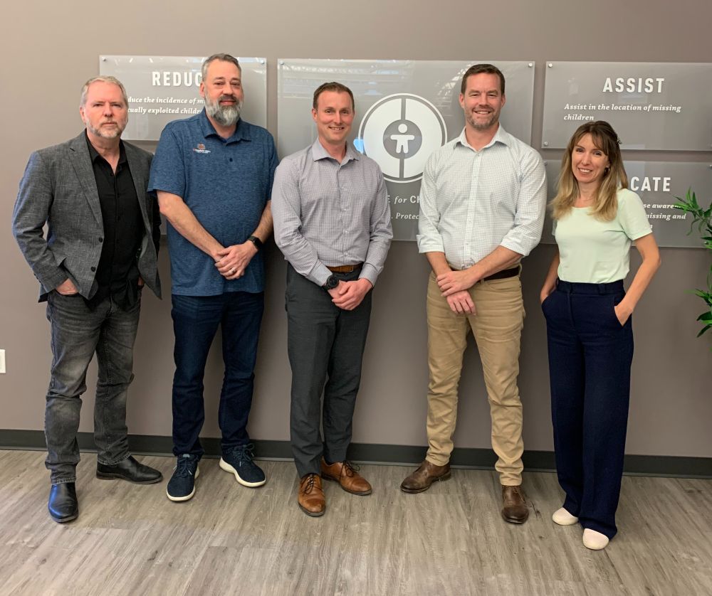 Professor John Rouse, Jim Cole, C3P director of technology Lloyd Richardson, Dr. Michael Salter, and Dr. Elly Hanson stand in front of Canadian Centre for Child Protection (C3P) logo.