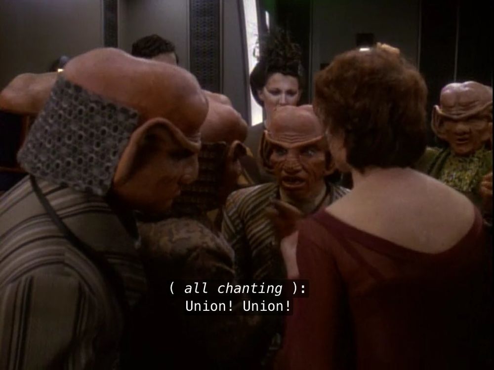 A screen cap from Star Trek: Deep Space Nine. A dozen characters are all chanting "Union! Union!"