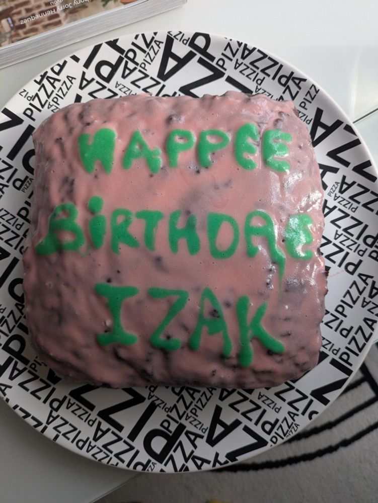 Un gâteau d'anniversaire sur lequel est écrit "happee birthdae izak" 