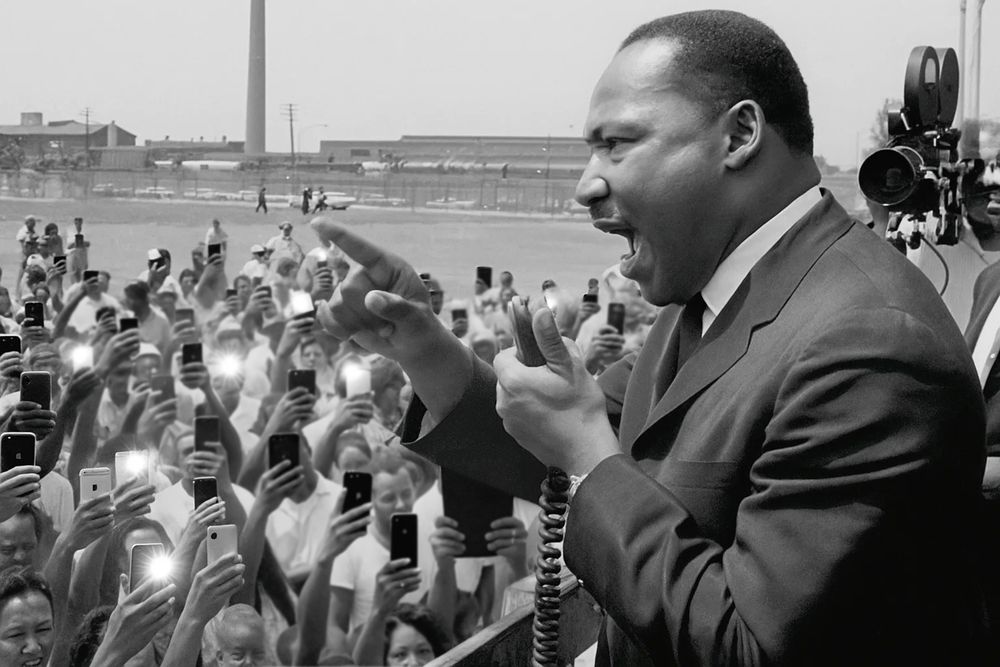 MLK speaks to a crowd in the 1950s using a bullhorn, and every audience member in attendance is seen holding up a phone to capture the moment.