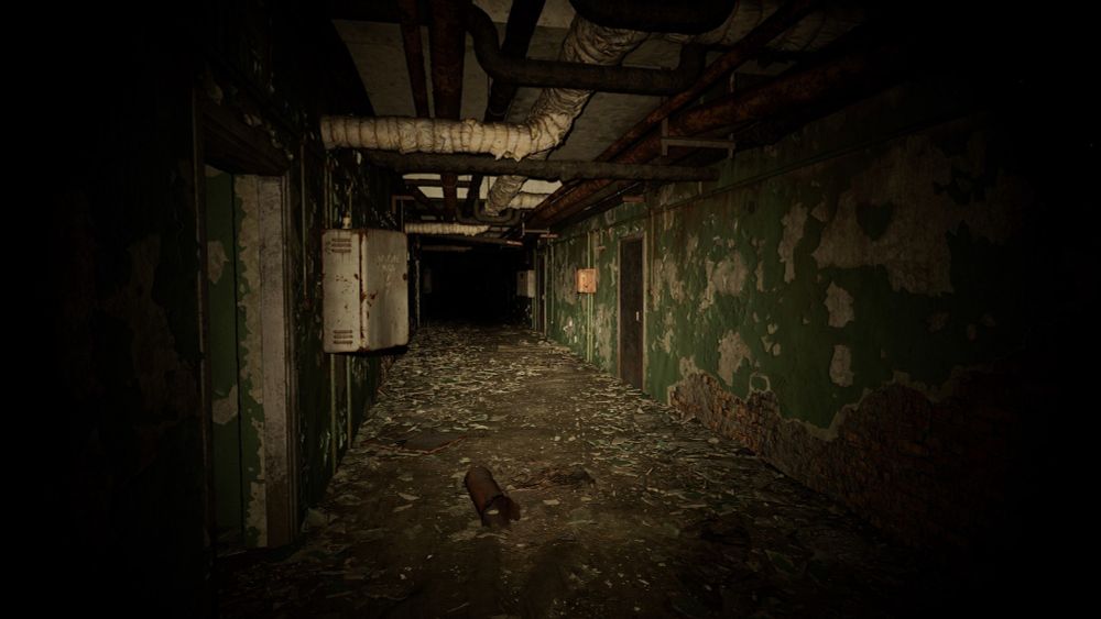 A screenshot from STALKER 2 videogame. A flashlight illuminates a decrepit underground corridor. Dozens of pipes are visible overhead, green paint peels off the walls, the ground is covered in dust and debris.