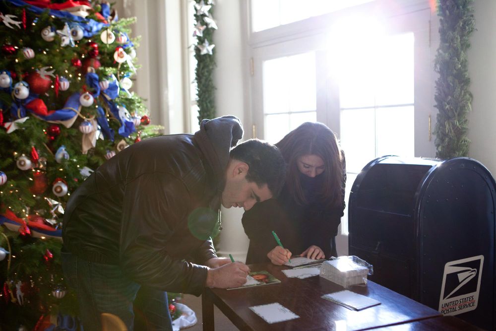 Visitors write cards to servicemembers in the East Wing Entrance.