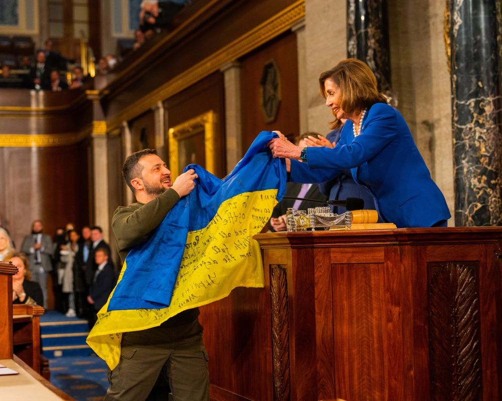 Ukrainian President Volodymyr Zelenskyy presents Speaker Nancy Pelosi with a signed Ukrainian flag in the House of Representatives.