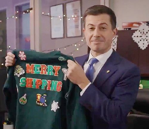 Pete Buttigieg holding up a sweater that says "MERRY SHIPPING" on it