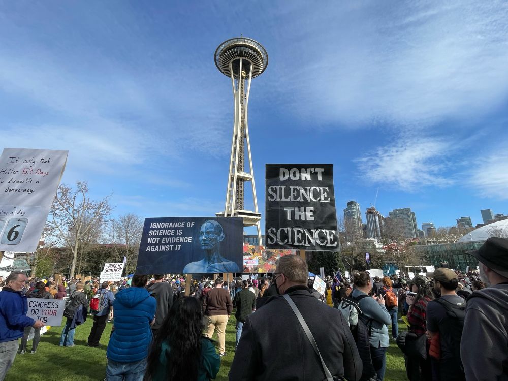 With the Space Needle in the background, here are two more signs at the science rally. The one on the left says, “Ignorance of science is not evidence against it” and the one on the right says, “Don’t silence the science.”