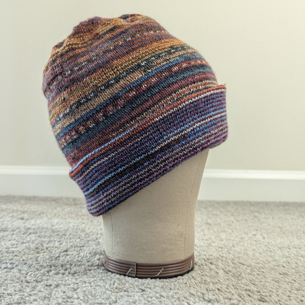 The oranges and blues side of the Musselburgh hat on a mannequin head.