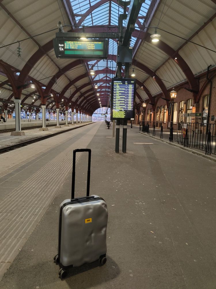 A silver suitcase on an empty platform.