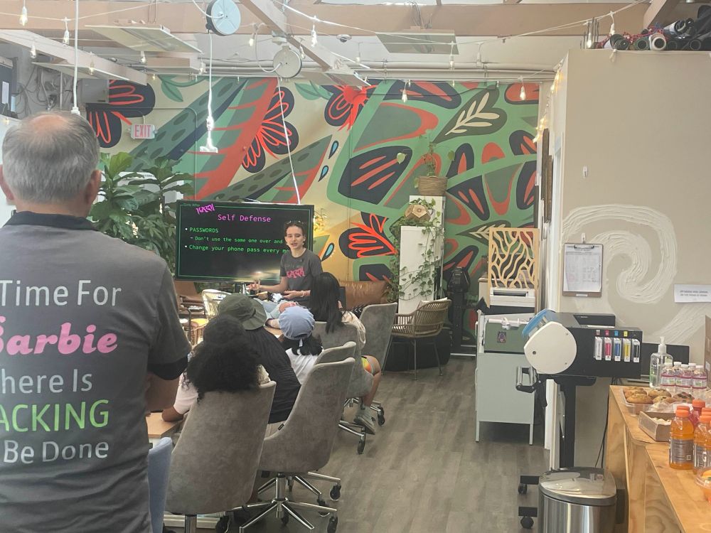 A young woman sitting on a table teaching cybersecurity